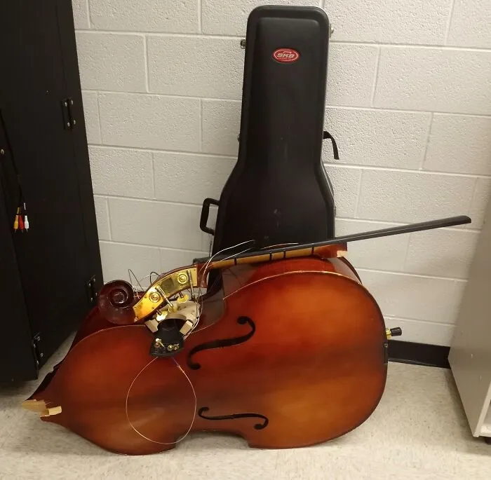 Violín roto junto a su estuche, ejemplo de accidente costoso.