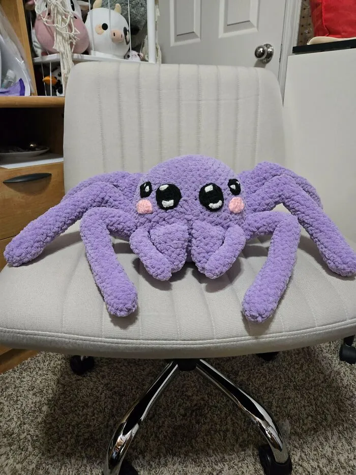 Crochet enthusiasts crafted an adorable large purple spider plush with big eyes and blush made from soft yarn.