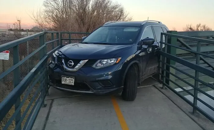 El conductor de un Nissan se queda atascado al girar en un puente peatonal del carril bici de Denver
