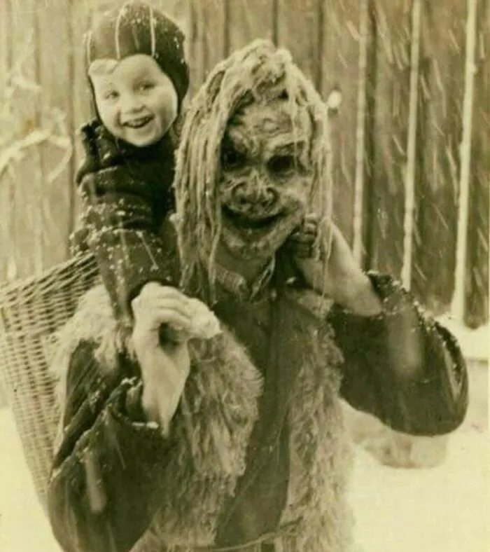 Un niño a hombros del Krampus durante un desfile en Mitterndorf, Austria, el 6 de diciembre de 1949.