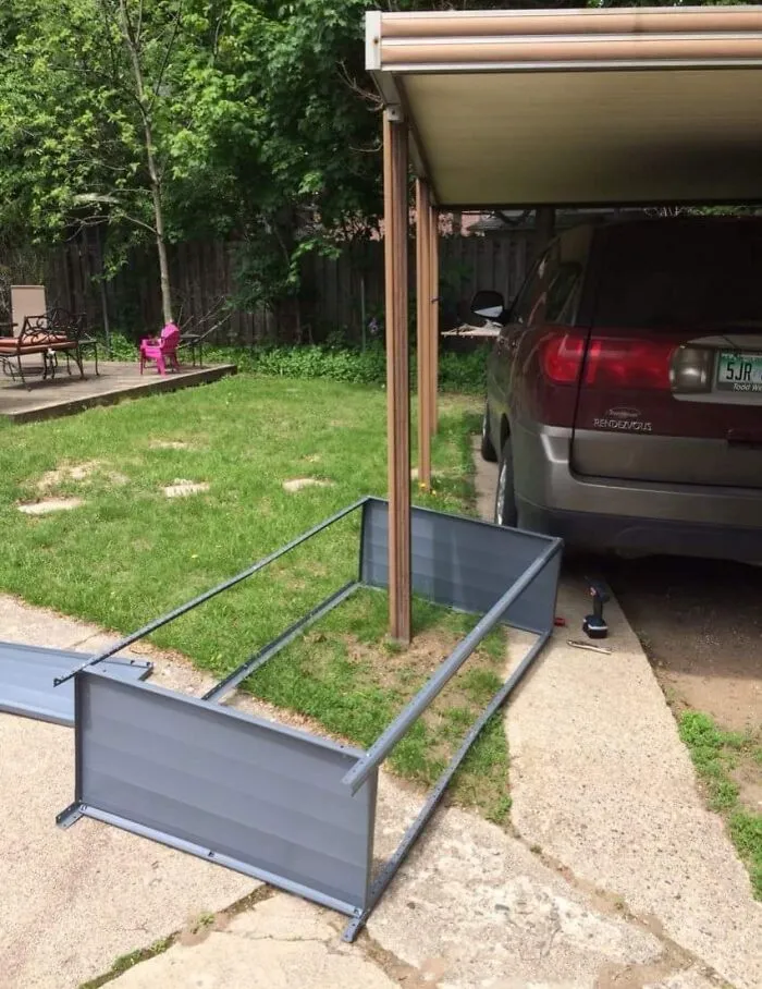Cochera improvisada con estructura metálica caída junto a un auto estacionado, resaltando errores compartidos en internet.