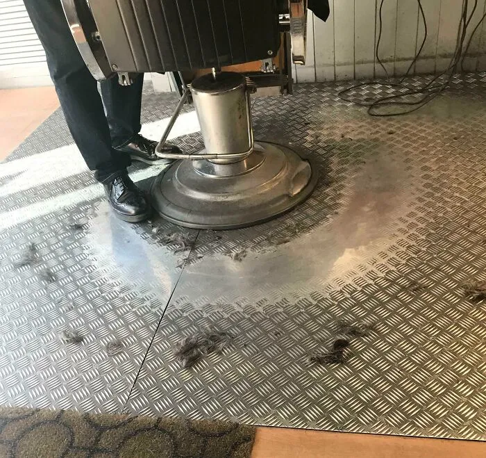 Nuestro barbero local lleva en el negocio desde que tengo memoria. El suelo metálico está desgastado donde camina alrededor de la única silla cada día.