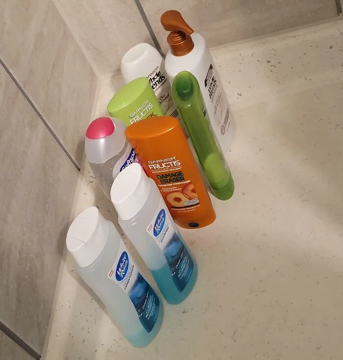 Varias botellas de champú y acondicionador en una ducha; ejemplo de familia política insoportable.