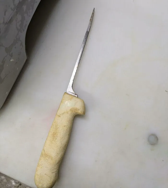 A worn knife with a well-used, discolored handle showcasing transformation by time and use.