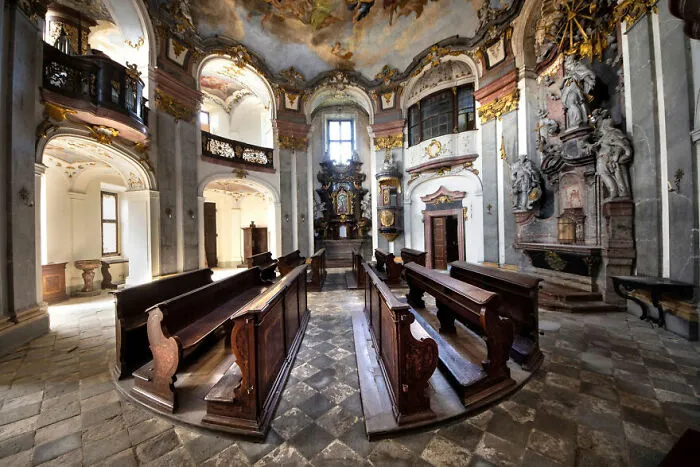 Abandoned church interior with ornate architecture and wooden pews, showcasing stunning and eerie decay.