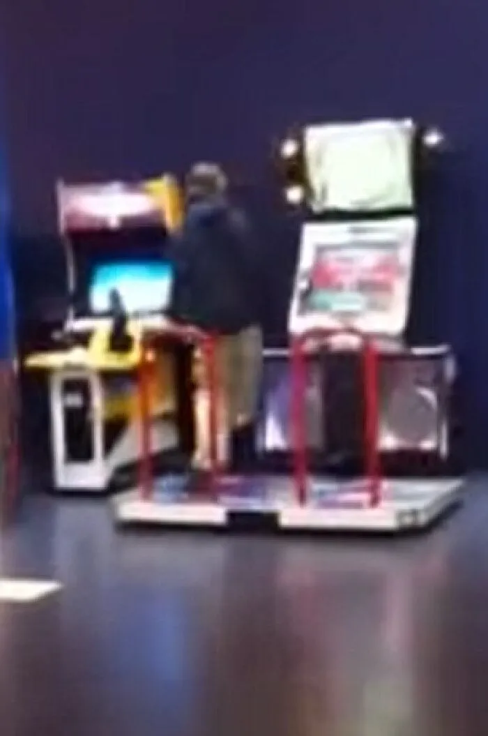 Persona junto a una máquina recreativa en un salón de juegos, imagen parece normal pero tiene historia inquietante.