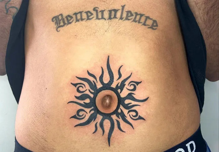 Navel sun tattoo design under the word "Benevolence," highlighting unattractive tattoos.