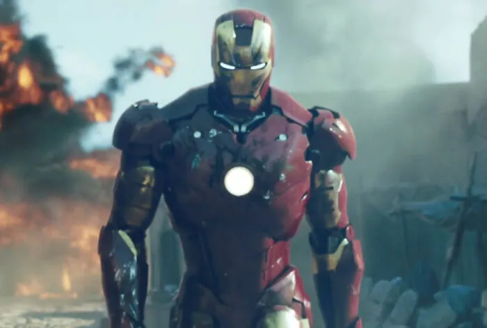 Iron Man in full armor walking through a destroyed area, exemplifying expectations met in action films.