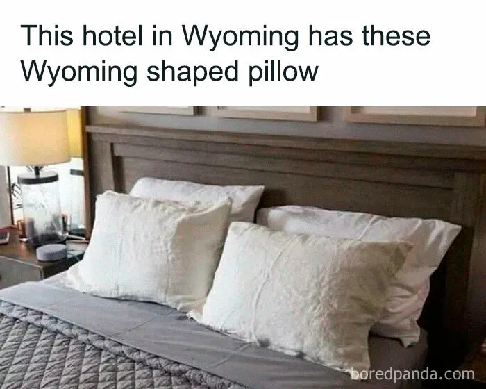 Wyoming hotel bed with Wyoming-shaped pillow, humorously highlighting random memes.