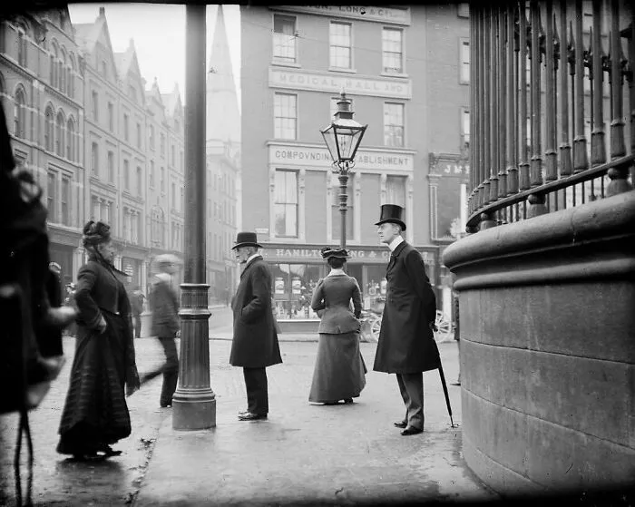 Victorian street scene with elegantly dressed individuals, adding a dash of nostalgia to the historical city setting.