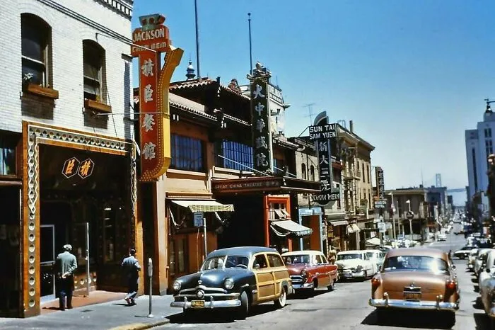 Vintage street scene with classic cars and historical architecture, evoking nostalgia.