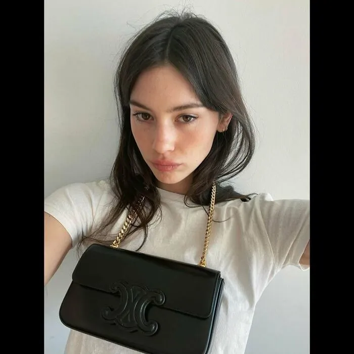 Young woman holding a designer handbag, illustrating the concept of not-self-made-celebs.