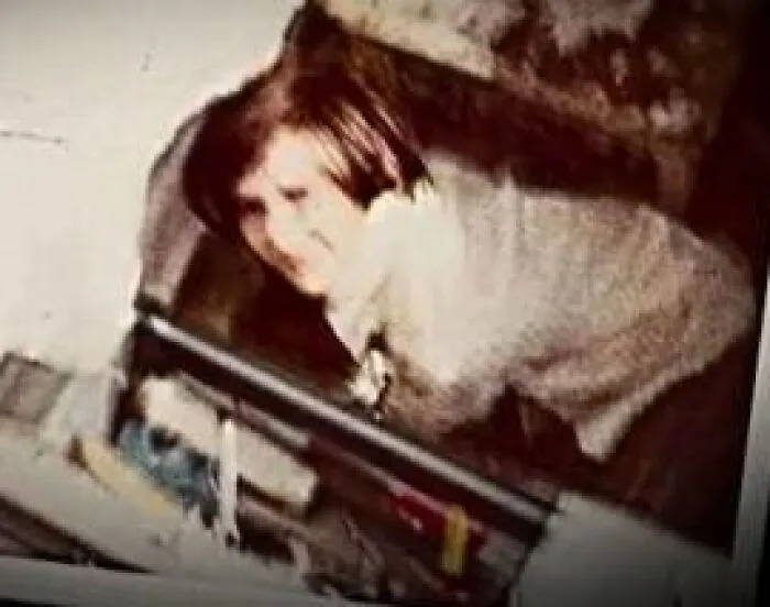A person in a dimly lit space with vintage tones, conveying a creepy historical ambience.