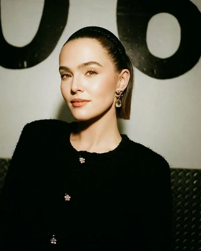 A woman with elegant attire and earrings, representing not-self-made-celebs against a stylish backdrop.