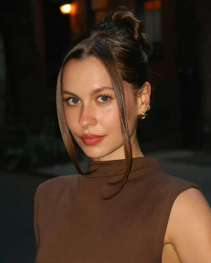 Young woman with brown hair and earrings posing outdoors, representing the concept of not-self-made celebs.