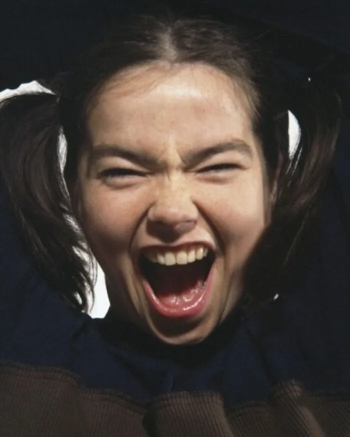 Young woman with pigtails, mouth open wide in excitement, capturing a dynamic historical moment.