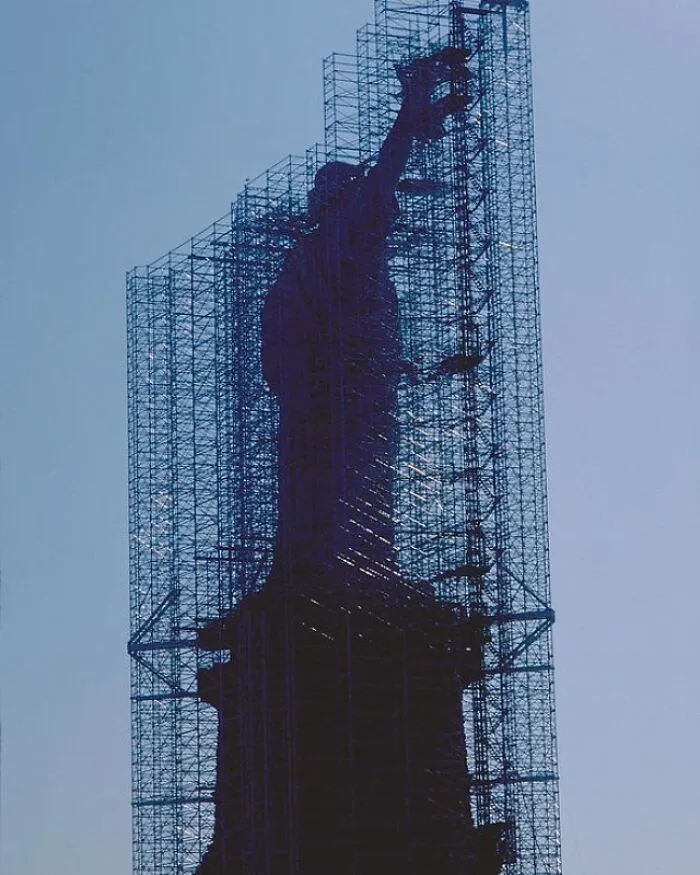 The Statue of Liberty surrounded by scaffolding during historical restoration work.