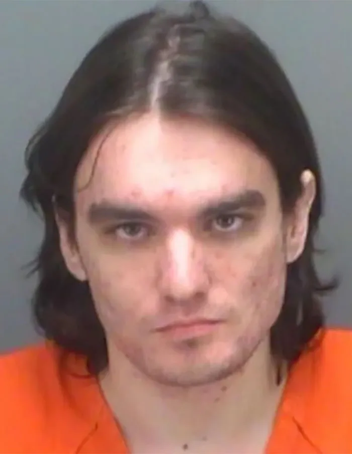 Man in an orange jumpsuit in a police mugshot related to crazy Florida Man headlines.
