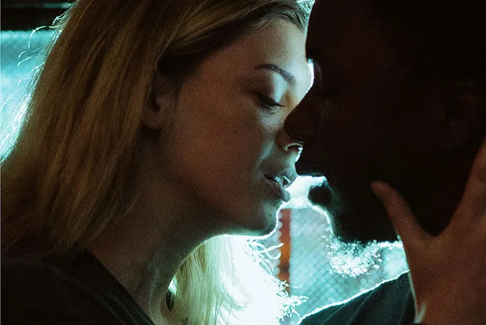 Two people close together in dim lighting, depicting a moment more than just friends.