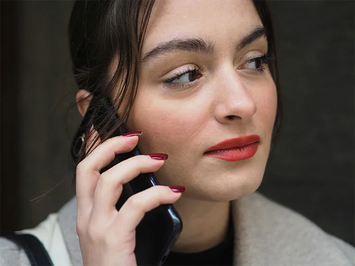 Woman on the phone, appearing concerned, dealing with dating issues.