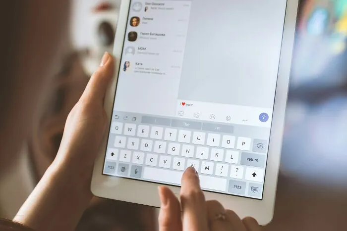 Typing a message on a tablet, highlighting gradually disappeared communication habits in digital era.