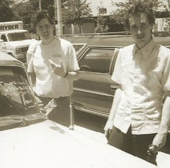 Dos personas junto a un coche clásico en una foto inquietante con historia oculta.