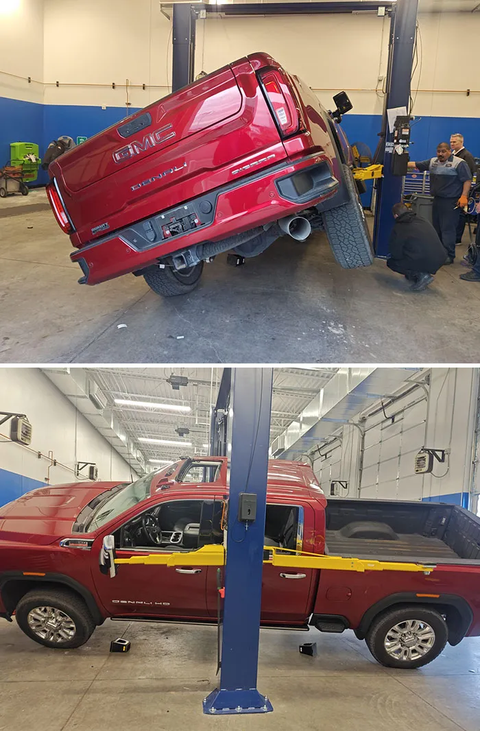Camioneta GMC roja inclinada en un taller, problemas en el trabajo.