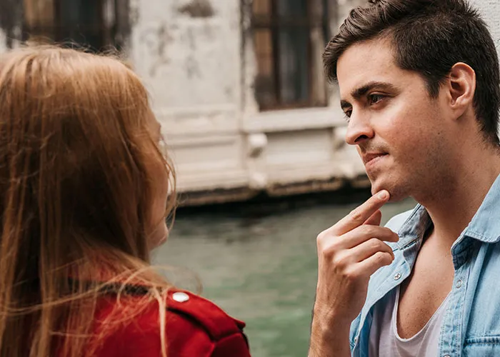 Man and woman in deep conversation by a canal, capturing curiosity about men.