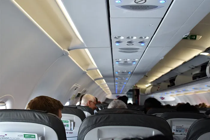Airplane cabin filled with passengers, highlighting a scene of chance encounters and coincidences in travel.
