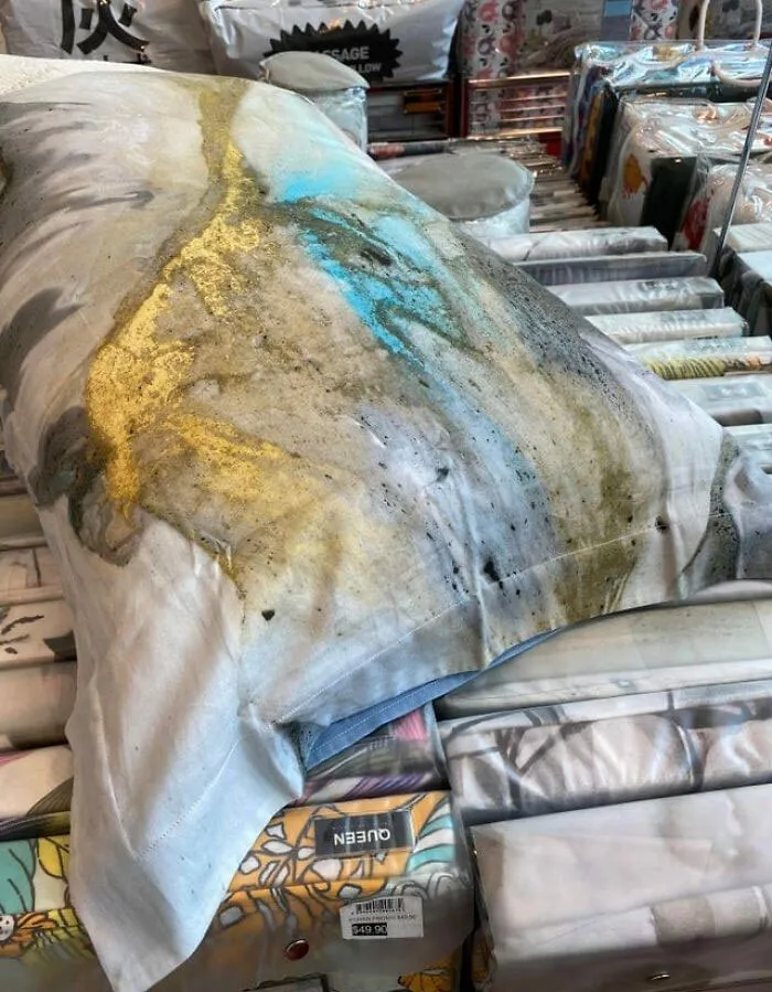 Funda de almohada con diseño abstracto en una tienda, presentando colores variados que resaltan en un entorno de venta minorista.