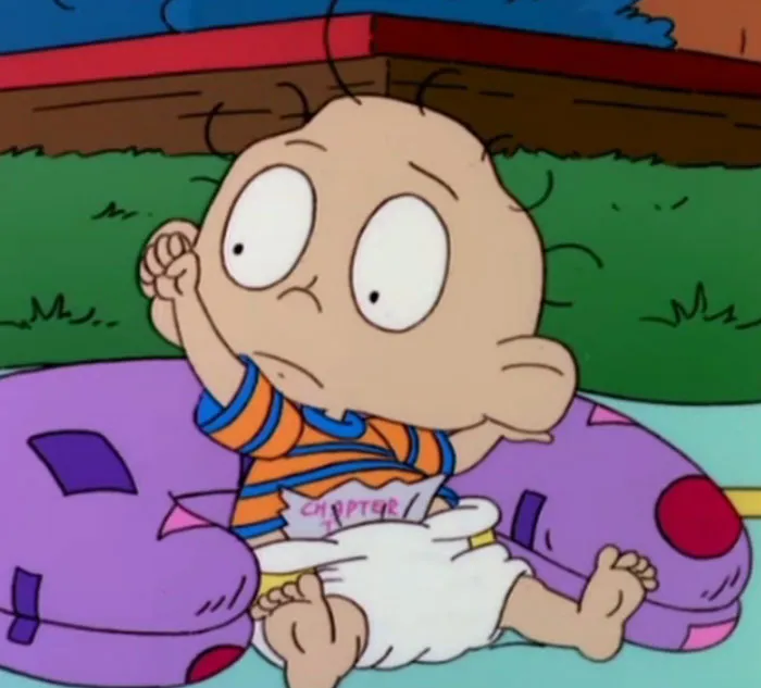 Cartoon baby on a colorful cushion, wearing a striped shirt and diaper, outdoors. Opportunity to learn new facts.