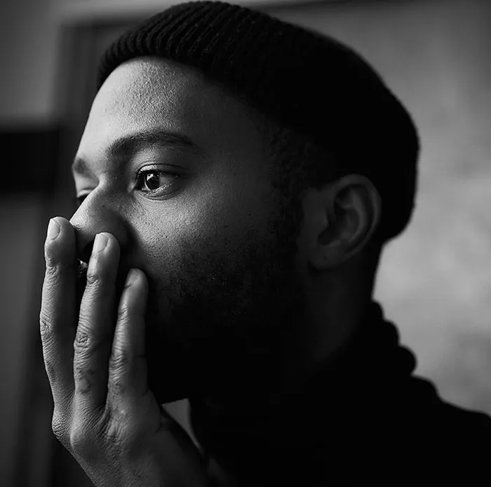 Man in deep thought, black beanie, represents split-second decisions, monochrome setting.