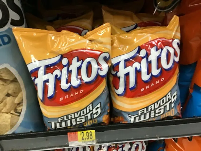 Fritos chips on store shelf with price tag, representing popular restaurant food items with rising prices.