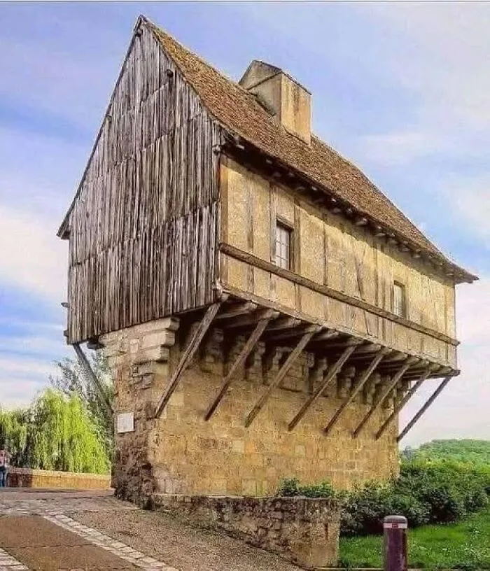 Medieval half-timbered architecture with wooden supports on a stone base showcasing historical archaeology design.