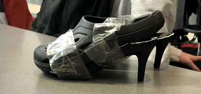Zapato reparado con cinta adhesiva, creando un diseño inusual que empeora el intento de mejora.