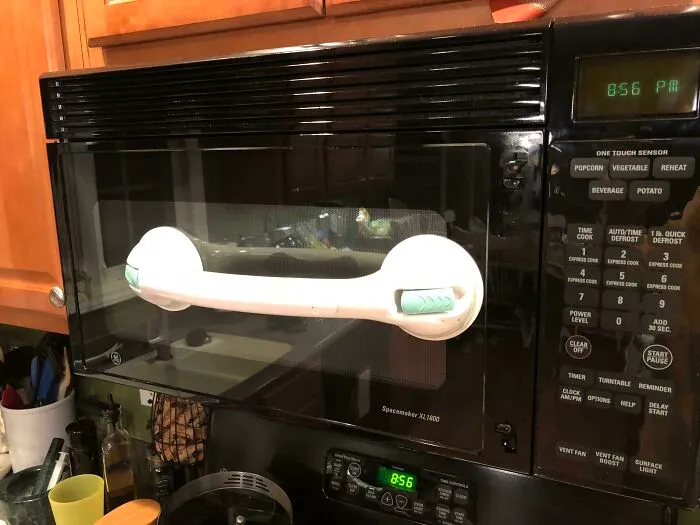 Manilla improvisada en un microondas como intento fallido de reparación.