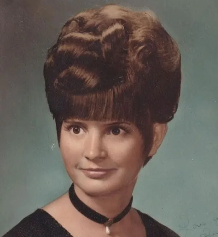 Vintage hairstyle featuring an intricate updo and bangs, embodying the unique fashion from yesteryear.