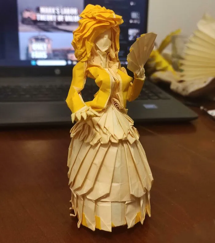An Origami Woman In Dress, Folded From A Single Square Of Paper