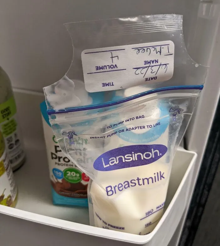Humorous coworkers' fridge prank with a labeled breastmilk bag next to protein drinks.