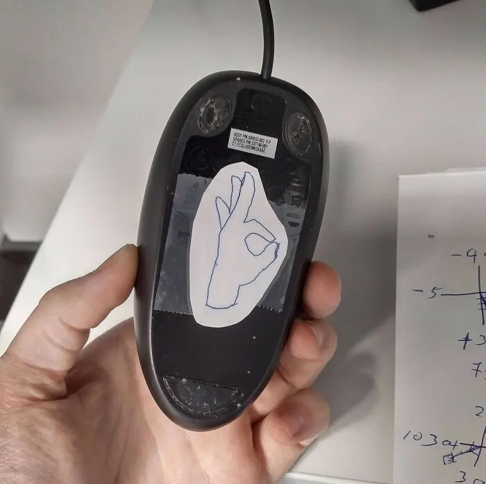 Mouse prank by funny coworkers, featuring a hand-drawn OK sign under the mouse.