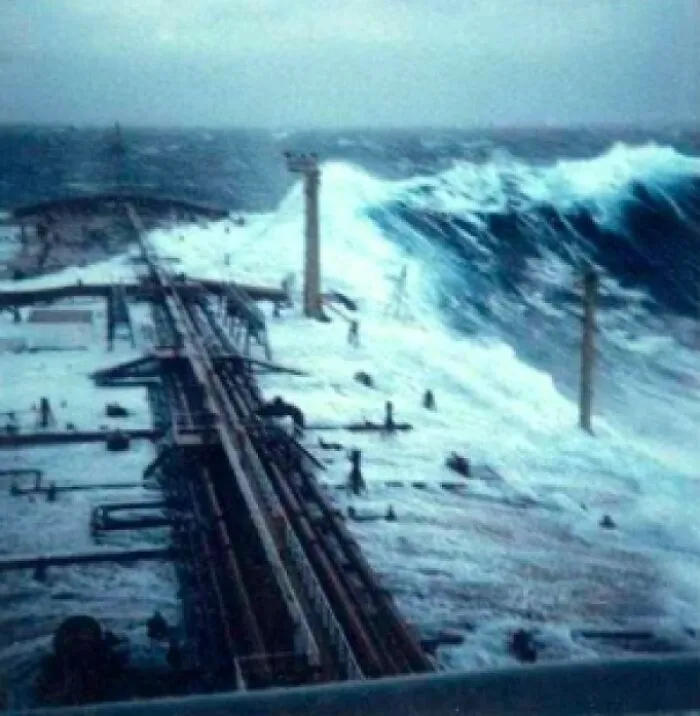 A massive wave crashing over a ship's deck, demonstrating the ocean's power and creating a terrifying scene.