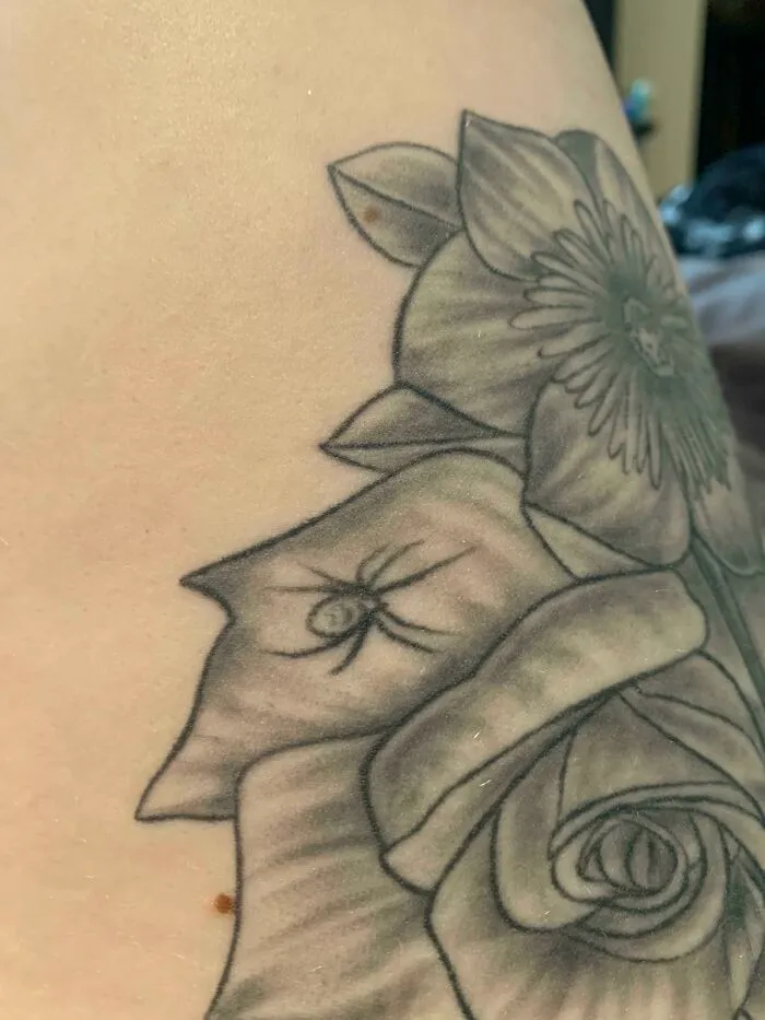 Tatuaje en blanco y negro de una rosa y araña que podría ser una mala elección en tatuajes según imágenes recientes.