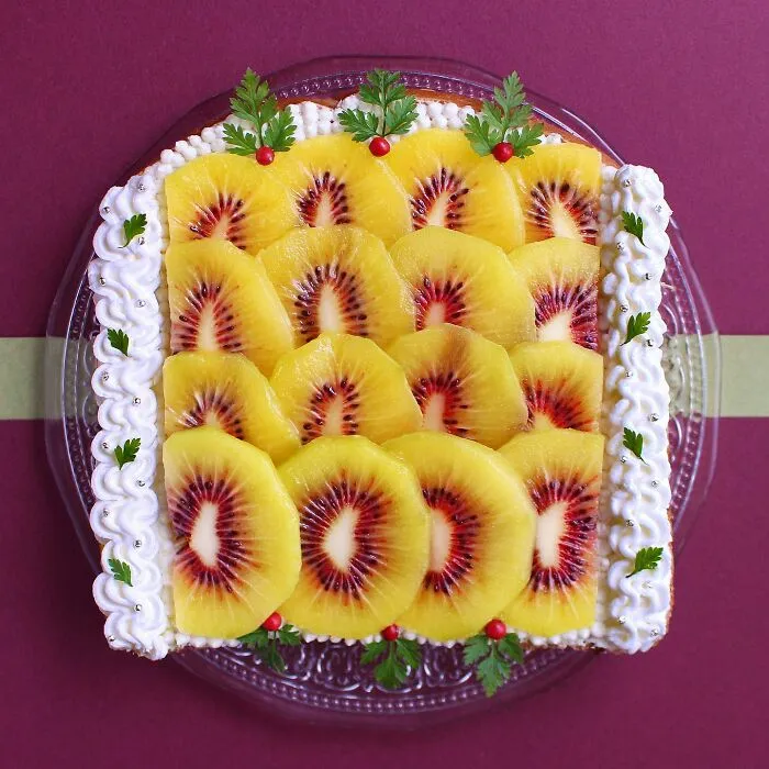 Creative toast design featuring vibrant fruit art with decorative garnishes on a clear plate.
