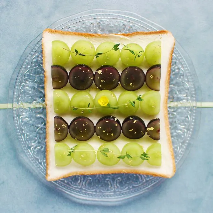 Creative toast design by Japanese artist featuring patterned grapes on a slice of bread.