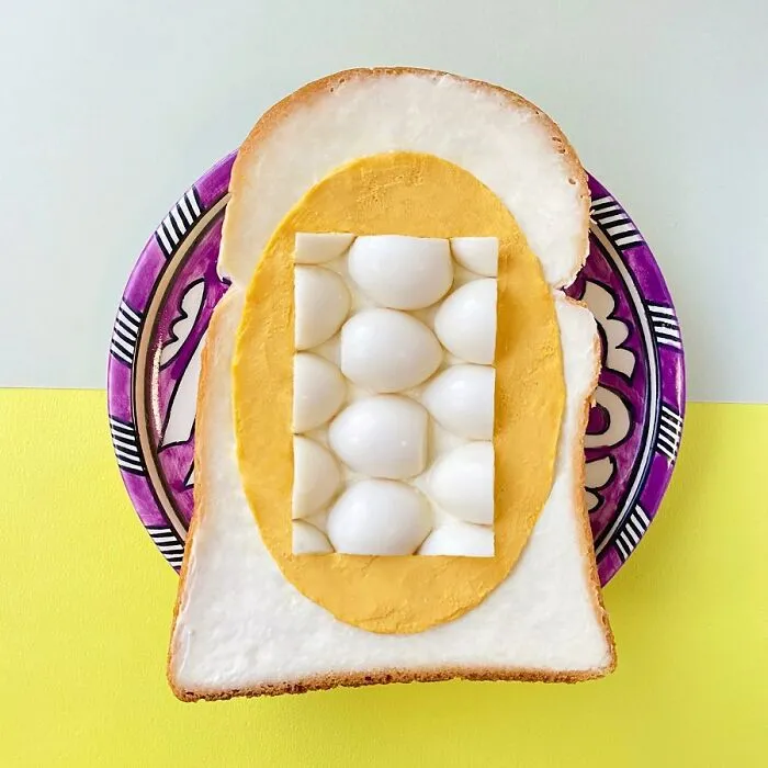 Creative toast design with layered eggs, styled on colorful plate.