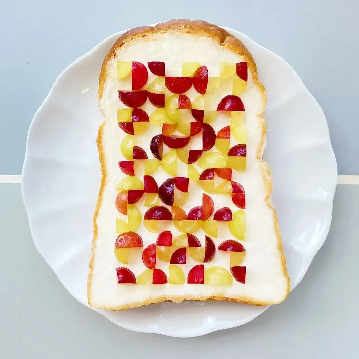 Creative toast design by a Japanese artist featuring a colorful geometric fruit pattern on a slice of bread.