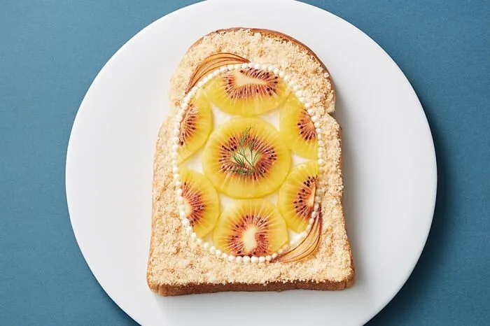 Creative toast design featuring kiwi slices on toasted bread by Japanese artist.