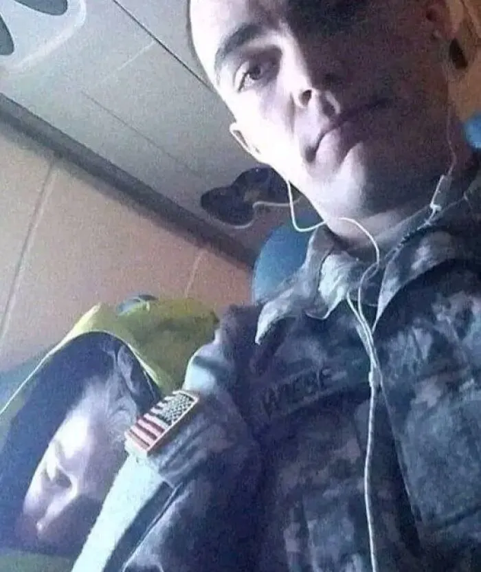 Man in military uniform on a plane, capturing a unique moment for "Forbidden Stories" collection.
