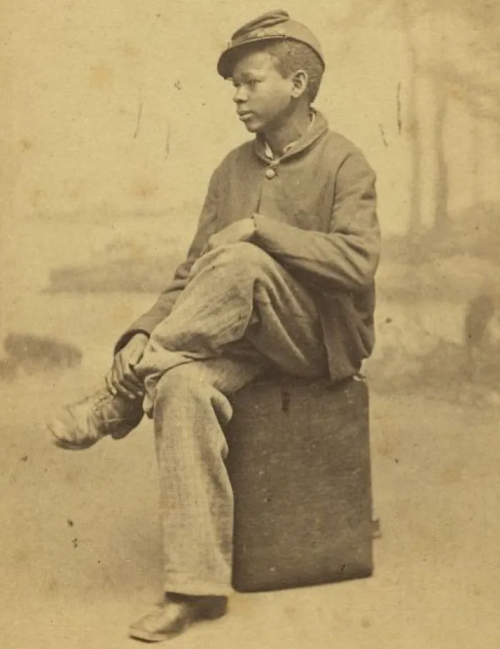 Young African American Boy Sitting On A Case, 1860-1870