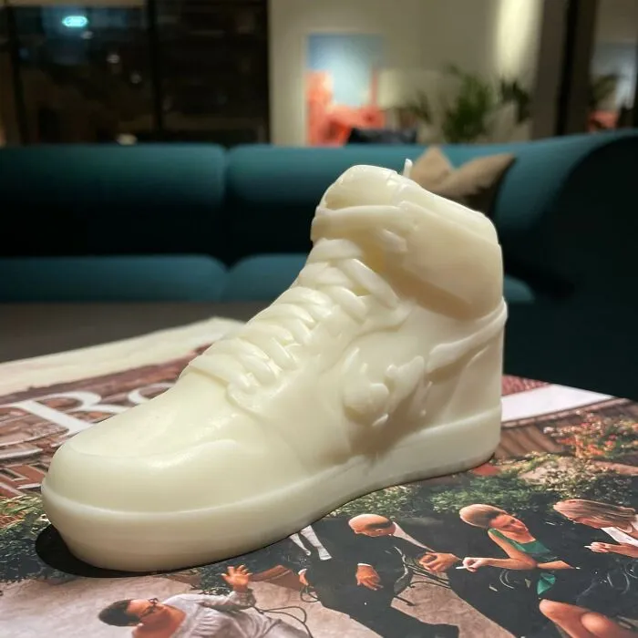Wax candle shaped like a sneaker on a table, showcasing creative candle design in a modern living room.
